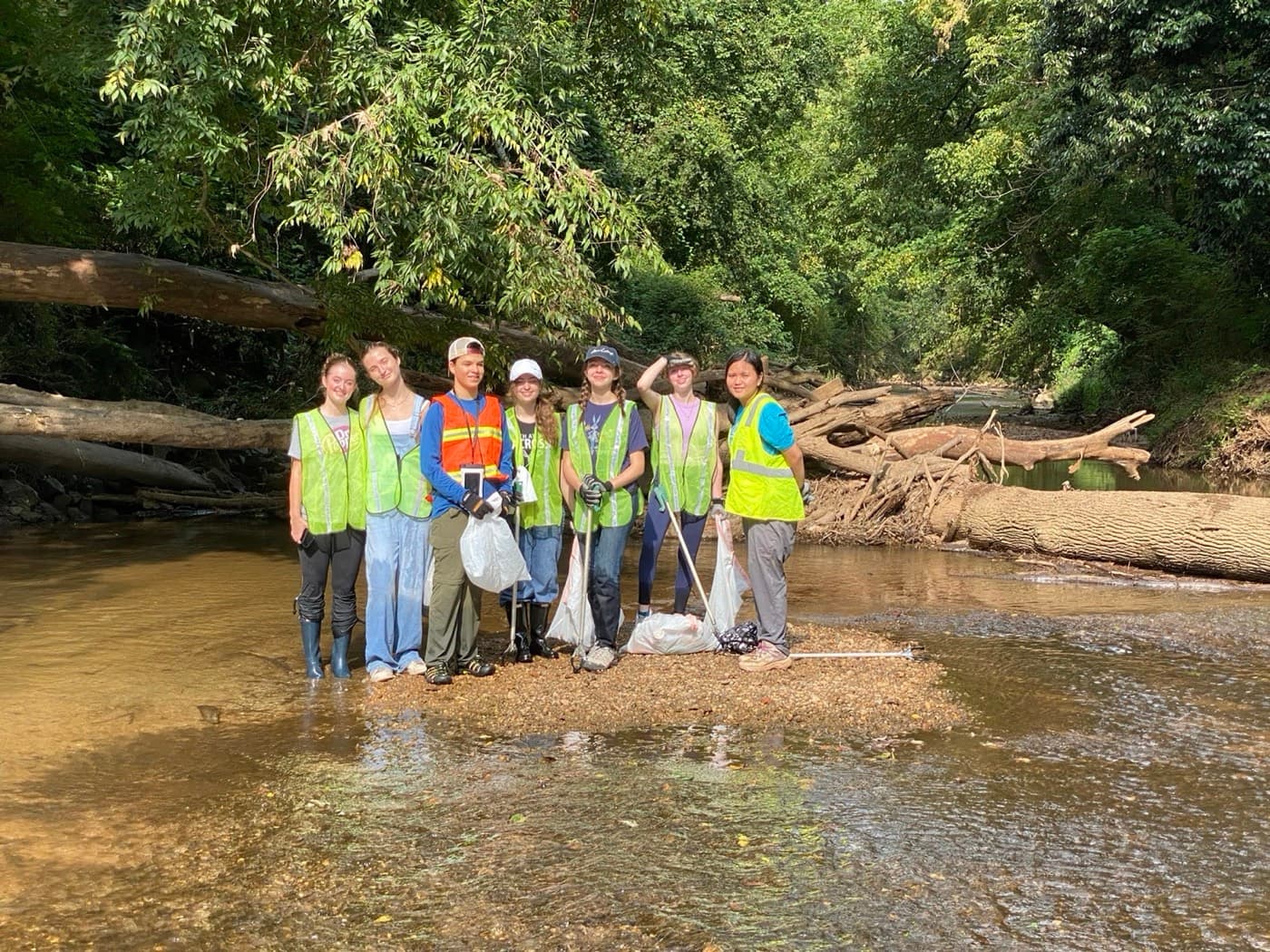 4 Green Futures volunteers cleaning up a creek